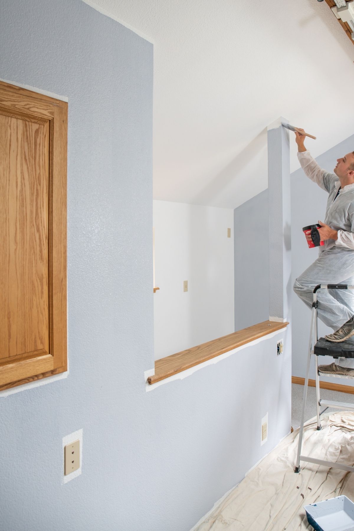 Peintre professionnel utilisant un rouleau pour peindre un mur intérieur à Beaconsfield