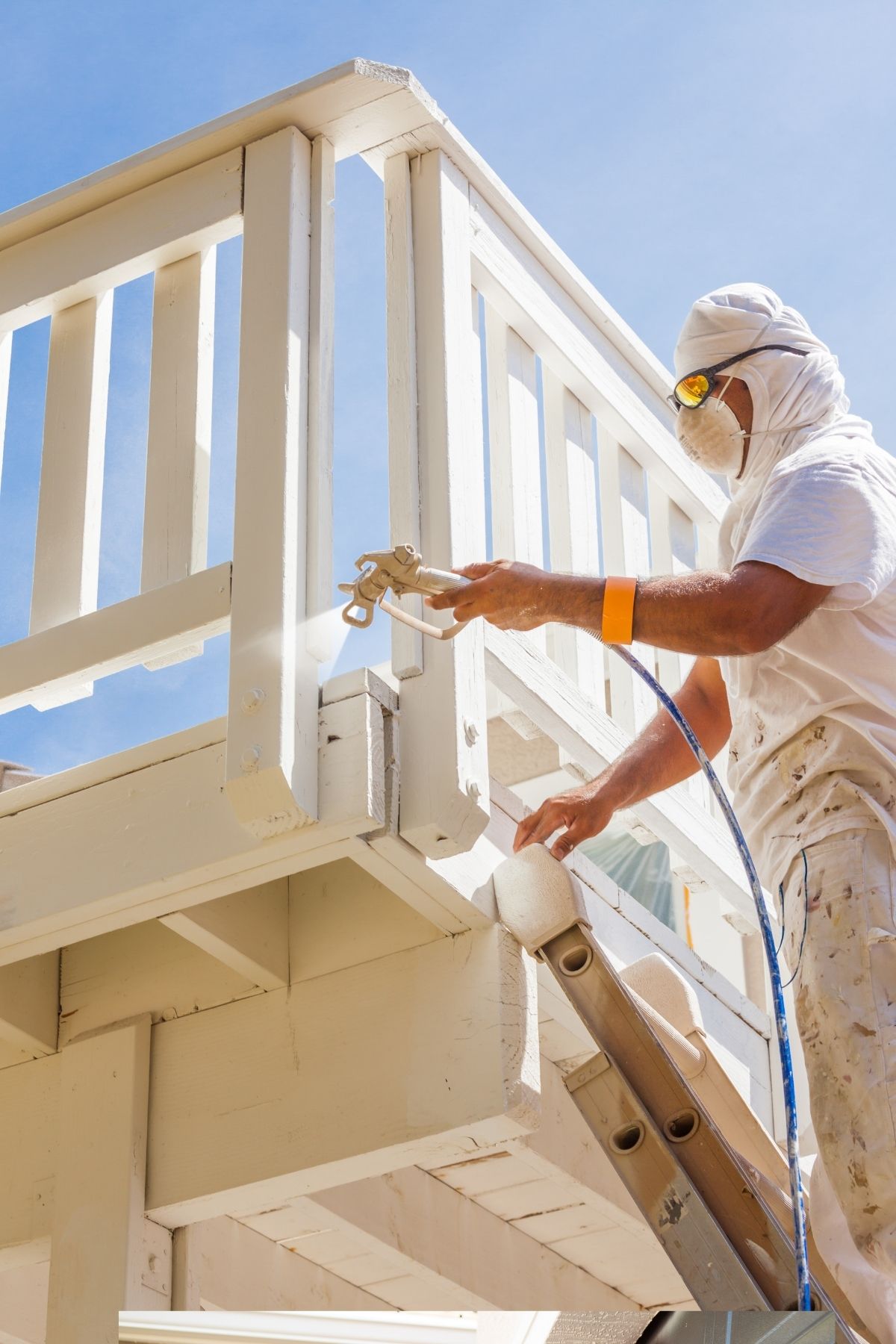 Peintre en bâtiment en Gaspésie - Iles-de-la-Madeleine appliquant une couche de peinture blanche